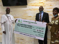 Most Reverend John Bonaventure Kwofie receiving the cheque from KSJI leadership