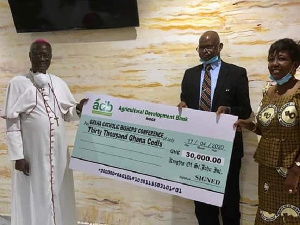 Most Reverend John Bonaventure Kwofie receiving the cheque from KSJI leadership