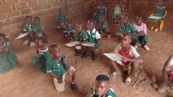 KG pupils sitting on stones