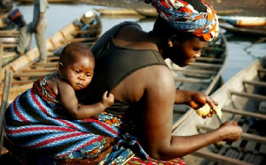 A working mother wraps her child at her back