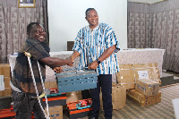 Hon Adansi-Bonah (right) presenting the items to PwDs