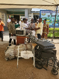 The Appianyinasehene (2nd R) presenting one of the items to officials of the hospital