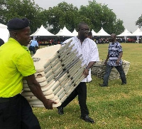 Sammi Awuku, National Organizer of NPP carrying chairs at C.K Tedam funeral rites in Paga