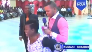 Obinim being carried by a lady in his church