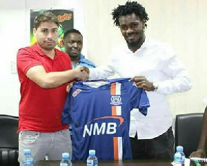 Yakubu Mohammed with an Azam offical posing with the club's jersey after the signing