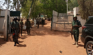 Nigerian soldiers and police officers stand at the entrance of the Federal College of Forestry