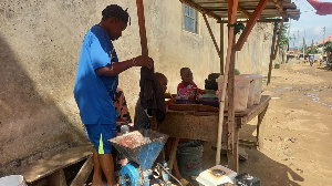 Fabian Grace awaits customers at her makeshift wooden stall