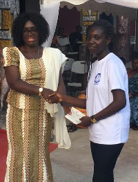 Deputy Educational Minister, Mrs Gifty Twum Ampofo presenting a cheque to one of the beneficiaries