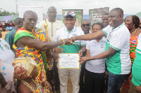 Gilbert Ken Asmah, presenting a certificate to the overall Municipal best farmer