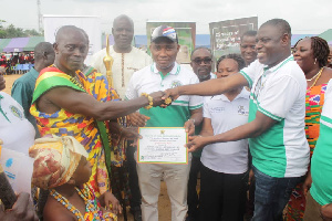 Gilbert Ken Asmah, presenting a certificate to the overall Municipal best farmer