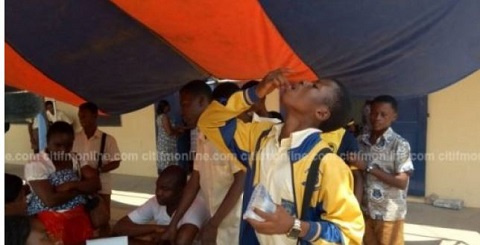 A student of Kumasi Academy taking his medicine