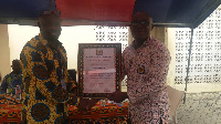 Kwame Agyemang Budu presenting a citation to one of the District Managers