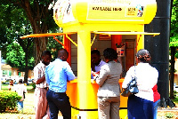 People accessing mobile money services at a vendor