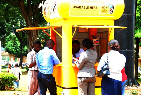 People accessing mobile money services at a vendor