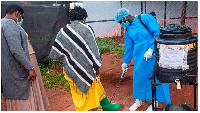 People disinfecting shoes in Mubende, Uganda