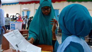 A Polling Agent (R) Explains The Voting Procedure To A Voter Before She Casts Her Ballot In Somali.p