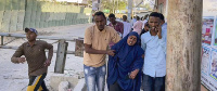 People flee from the area as gunshots are heard, on a street near the Afrik hotel in the capital Mog