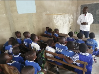 An official of Human Rights Reporters Ghana interacting with JHS pupils