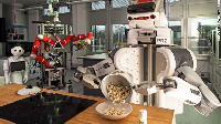 A robot pours popcorn from a cooking pot into a bowl at Bremen University, Northwestern Germany