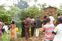 Residents surround the home of the deceased