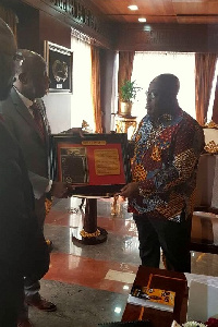 Dr. Thomas Mensah presenting a plaque to President Akufo-Addo