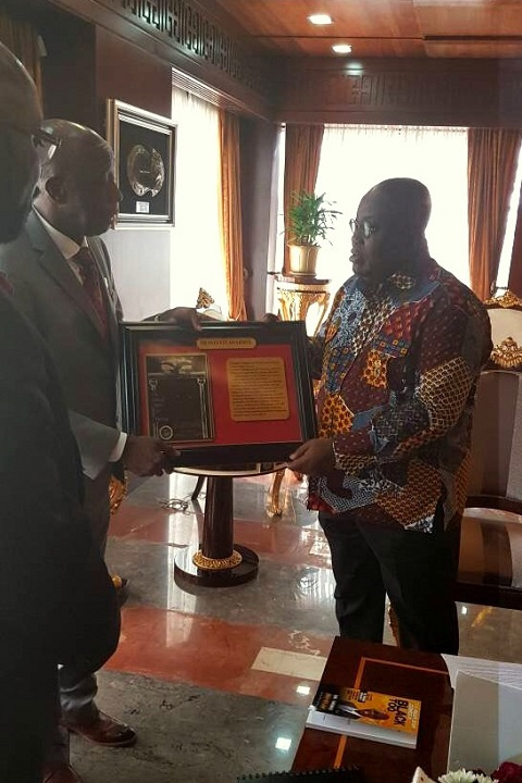 Dr. Thomas Mensah presenting a plaque to President Akufo-Addo