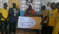 Peter Bimpeh, right presenting the cheque to Osabarima Adusei Peasah IV, Chief of Akyem Tafo