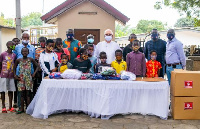 Fr Andrew Campbell  receiving items from  MASK4ALL Ghana