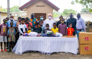 Fr Andrew Campbell  receiving items from  MASK4ALL Ghana