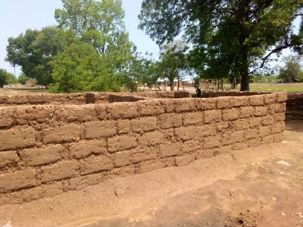 Community members are putting up a brick house for a newly posted nurse