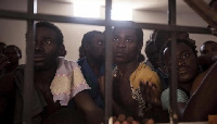 Image shows a group of migrants in a cell