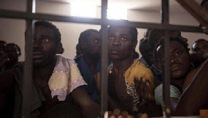 Image shows a group of migrants in a cell