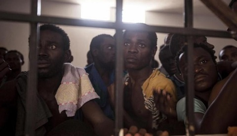 Image shows a group of migrants in a cell