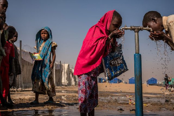 File photo of children drinking water from a pipe stand