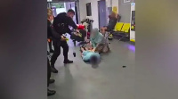 The officer is seen to repeatedly kick the man, who is lying face down