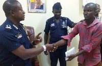 DCOP Quainoo (left) presenting the cash to the hunter