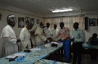 Sarfo Kantanka presenting the Cheque to Archbishop Palmer-Buckle while the other Bishops look on.