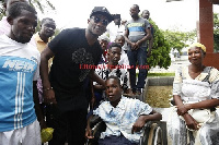 Asamoah Gyan (2nd left) meets the Physically challenged boy