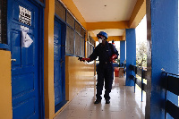 A staff disinfecting an office