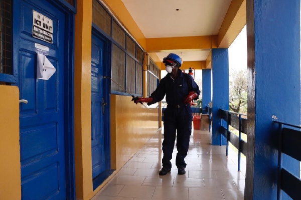 A staff disinfecting an office