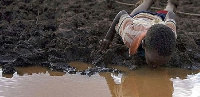 A boy drinking dirty water