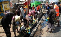 Some residents cleaning  choked gutter in the area (File photo)