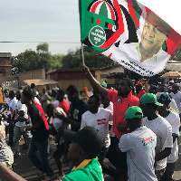 John Dumelo holdinf NDC flag campaigning for Mahama