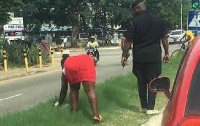 The woman being led by police to clean a stretch of the Kejetia road