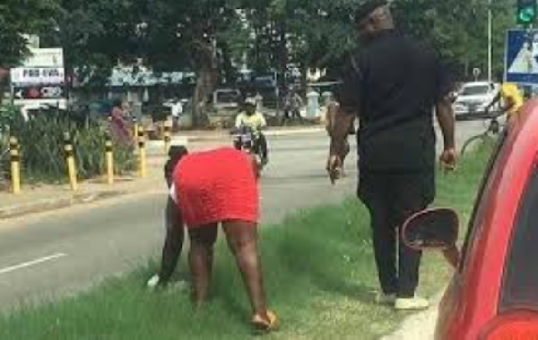 The woman being led by police to clean a stretch of the Kejetia road