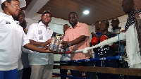 Peter Zwennes presenting some items to Isaac Dogboe