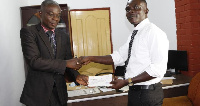 General-Secretary of Opticians Association of Ghana, Frank Ofori  presenting a cheque to Mr Boakye