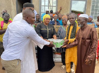 Theresa Awuni presenting food items to Muslims