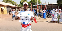 A party supporter holding a paper with the inscription, 'Minister must go'