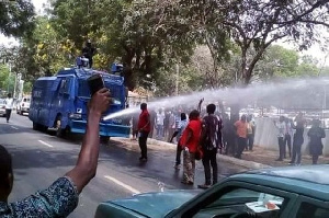 Water cannons containing hot chemical solution being used on protestors